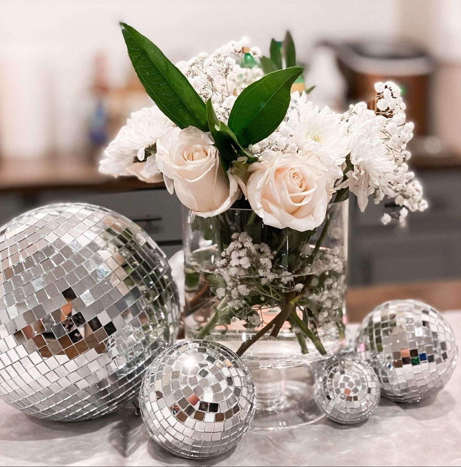 Assorted silver mirror disco balls adding sparkle to a bridal shower tablescape.