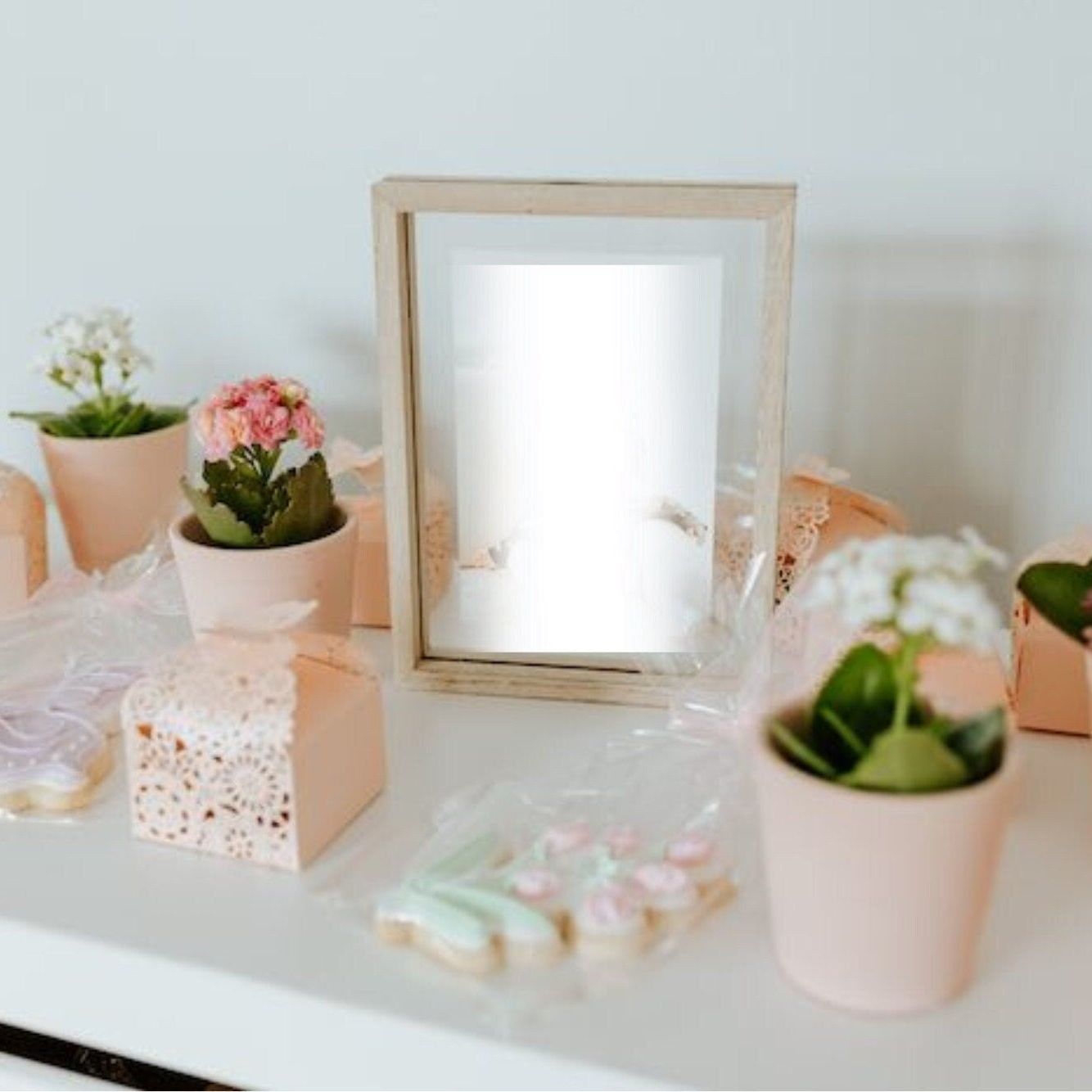 Baby shower setup with butterfly favor boxes, flowers, and elegant décor