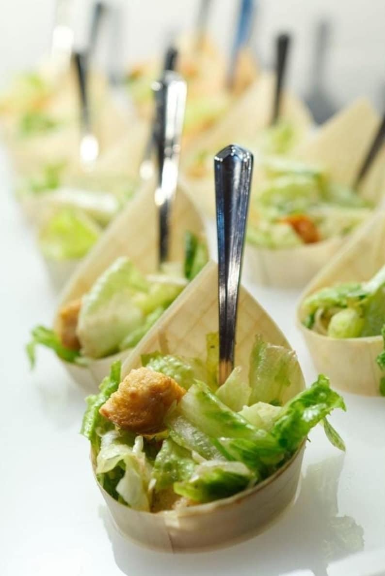 Bamboo appetizer cups filled with salad and mini forks for events