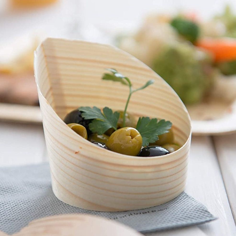Bamboo cups filled with colorful appetizers and hors d'oeuvres at elegant party setting