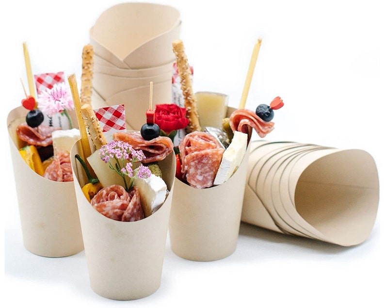 Beige charcuterie cups filled with meats, cheeses, and appetizers for parties.
