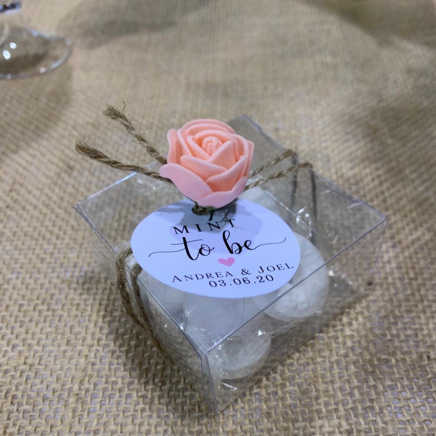 Rose and tag tied around a clear cube favor box for a bridal shower