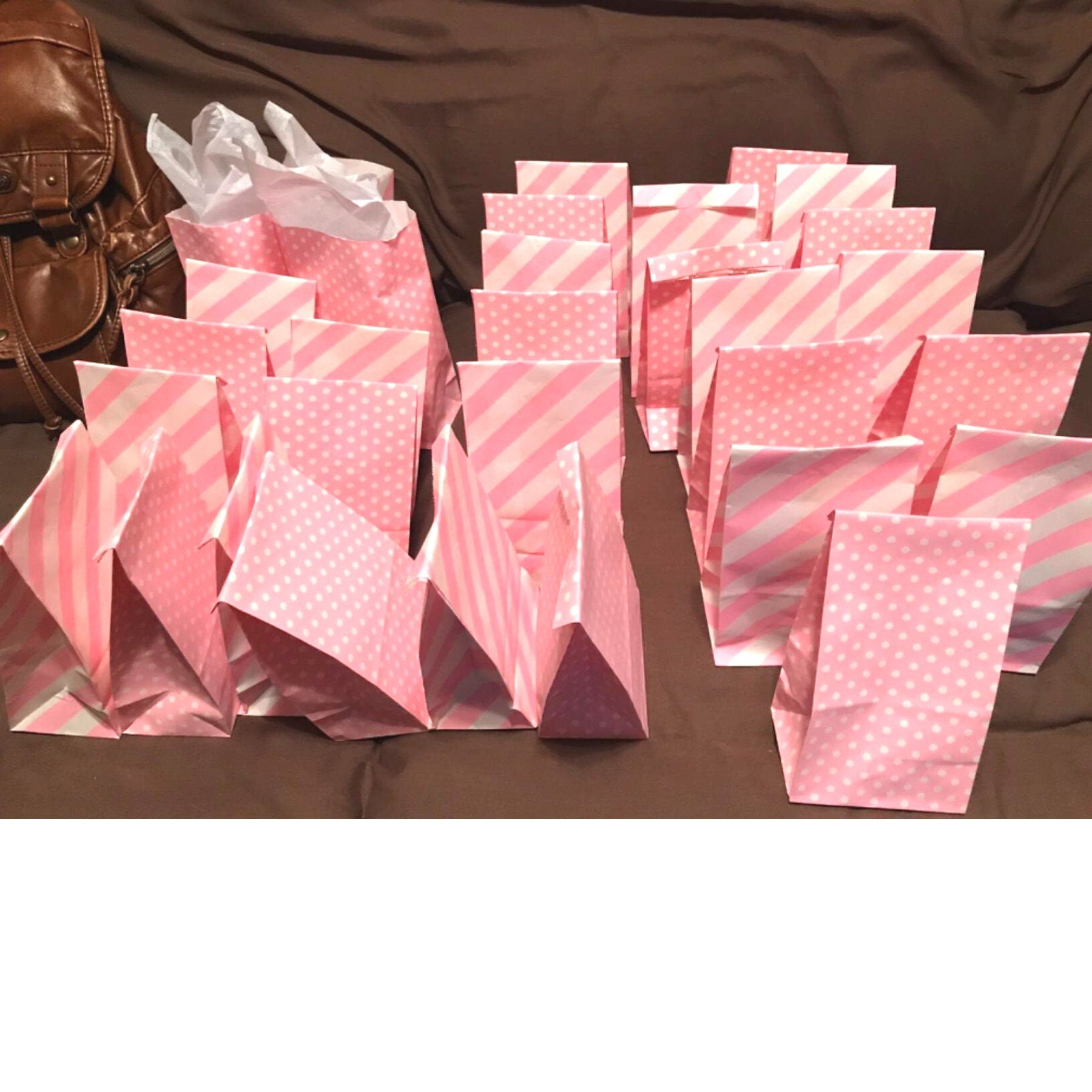 Bulk set of pink striped and polka dot paper bags displayed on table