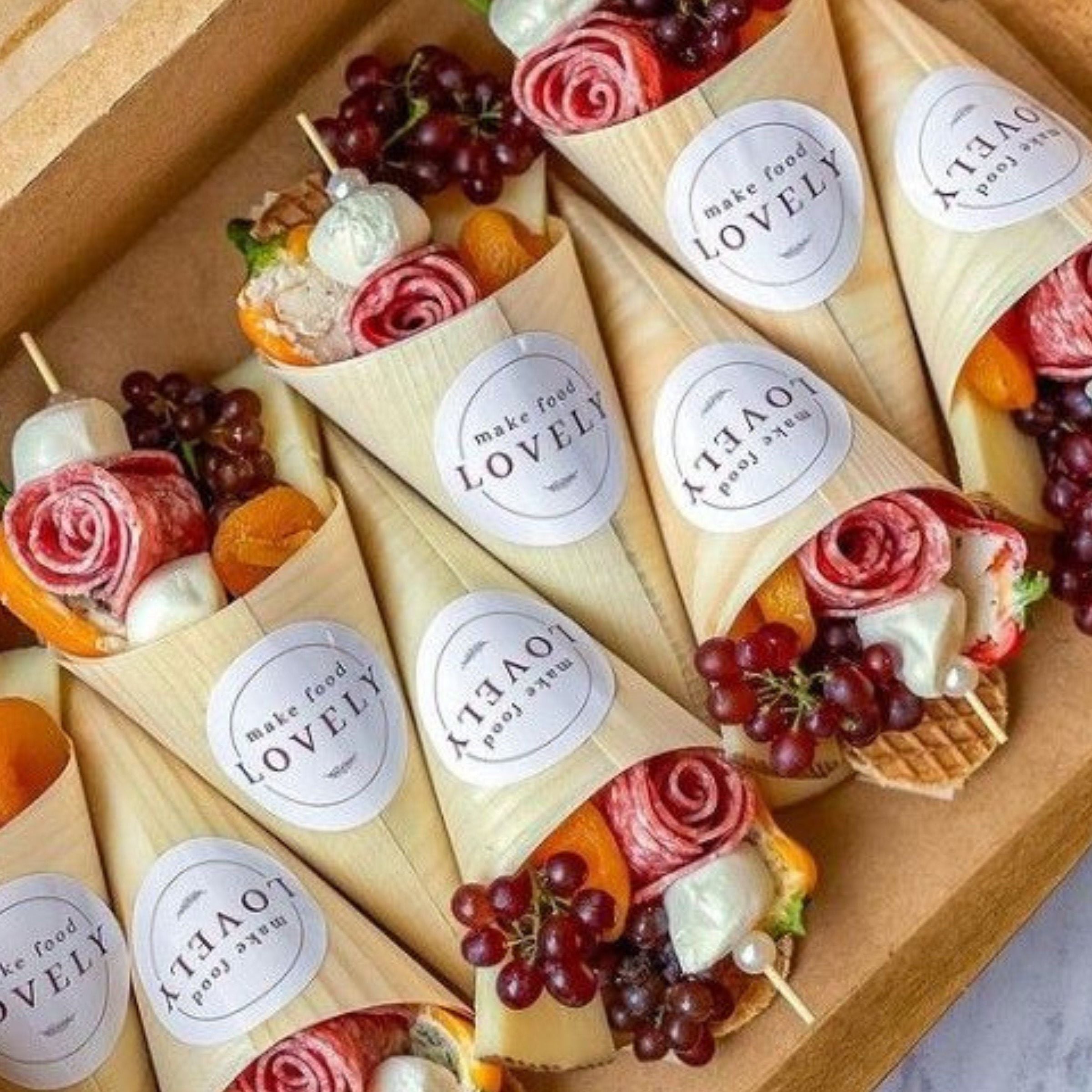 Charcuterie bamboo cones filled with meats, cheese, and fruit for grazing table