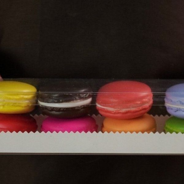 Black base macaroon box displaying assorted macarons behind clear lid