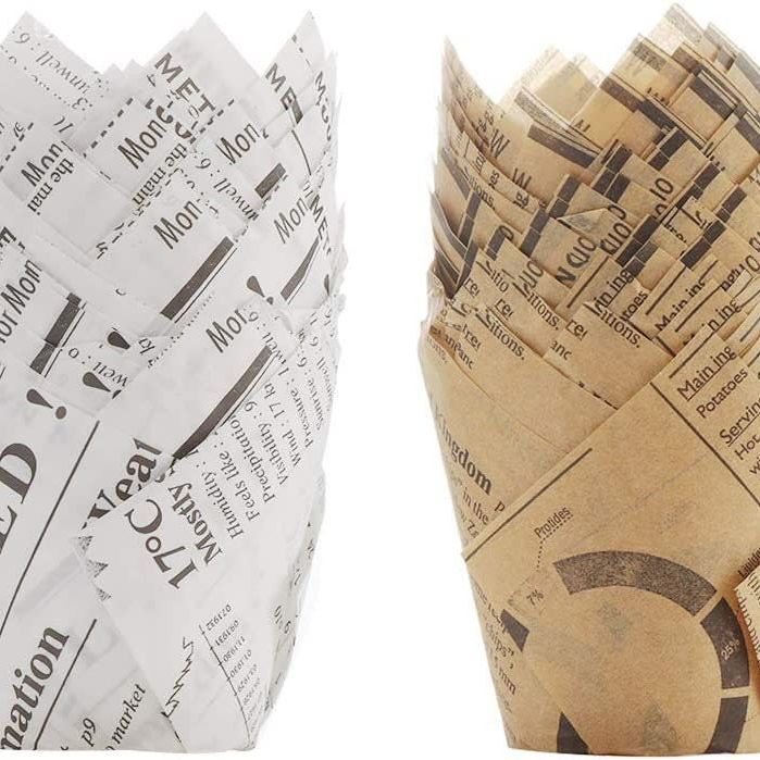 Set of 20 disposable newspaper charcuterie cups arranged with matching fancy toothpicks for party setup