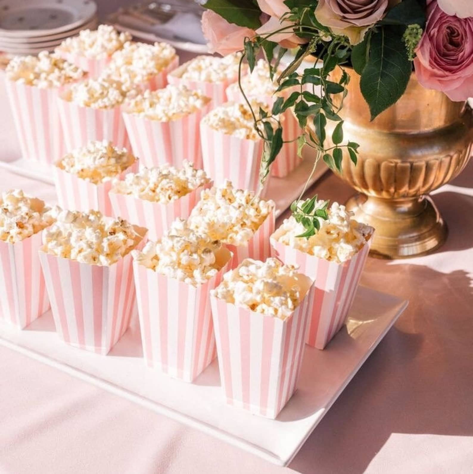 Customizable striped popcorn cups featuring logos and stickers at a wedding dessert station.