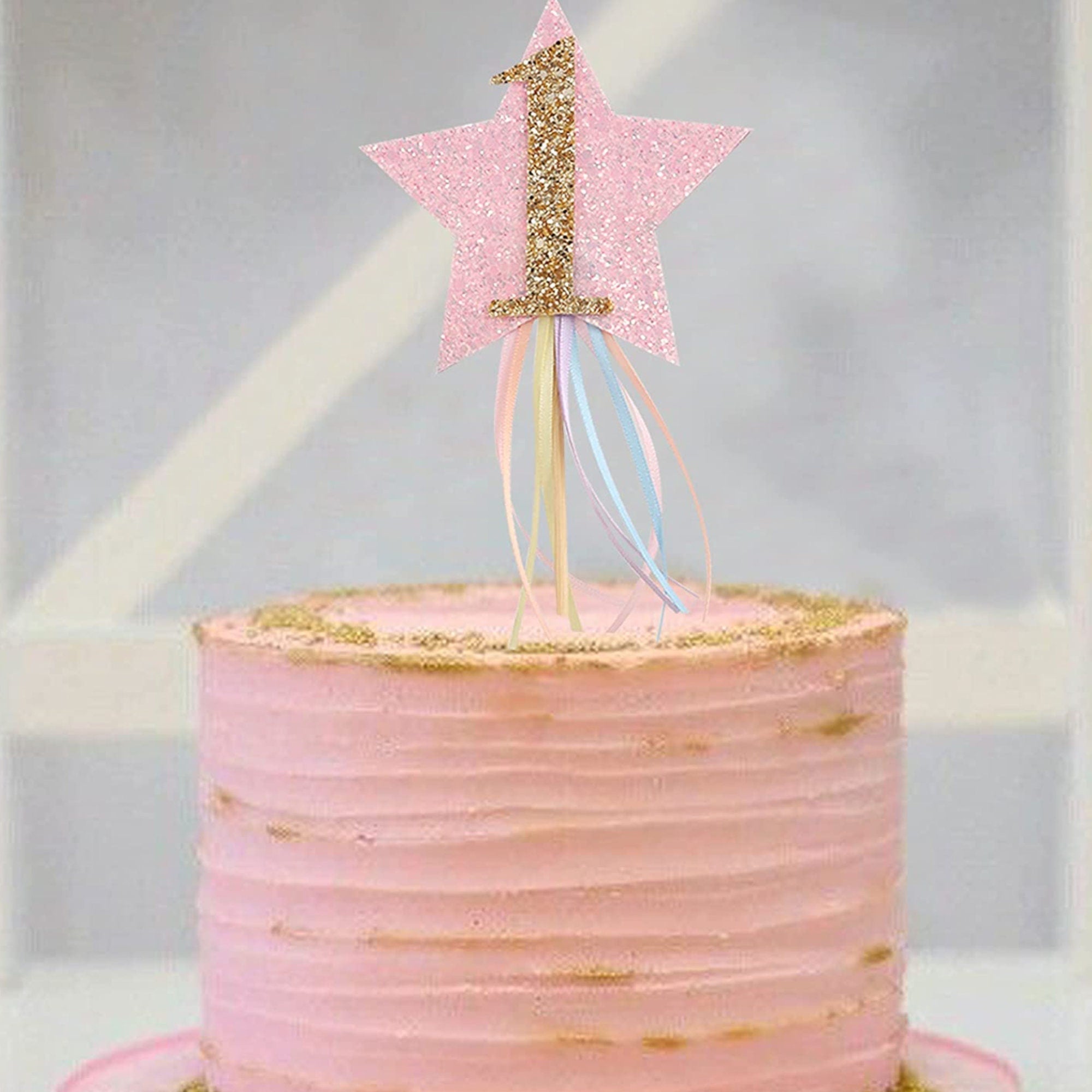 First birthday cake with gold star topper, moon decorations, and white pearl accents