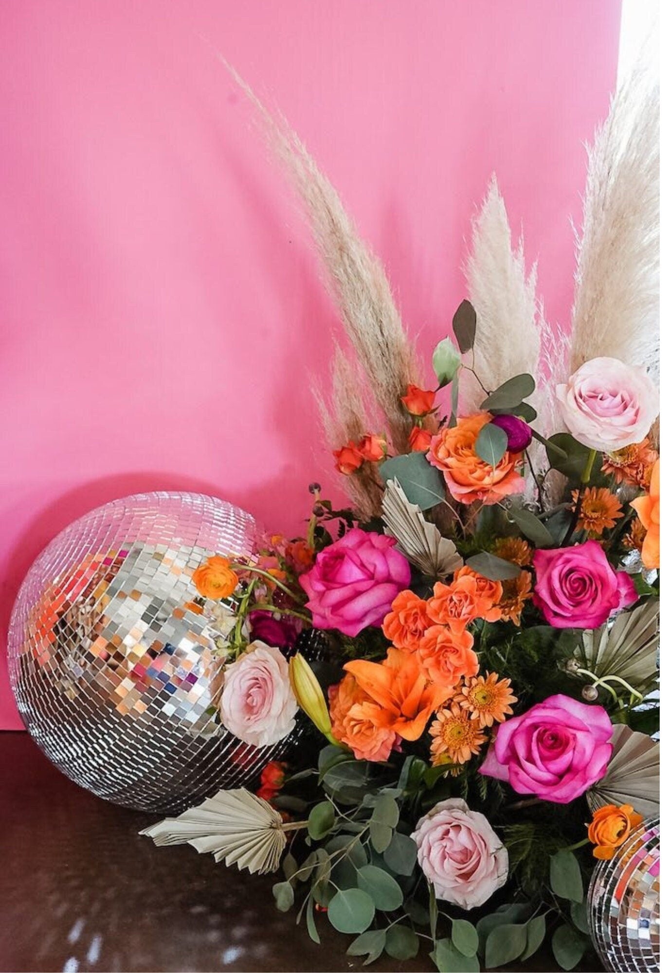 Silver disco ball styled with bright floral arrangement for event décor