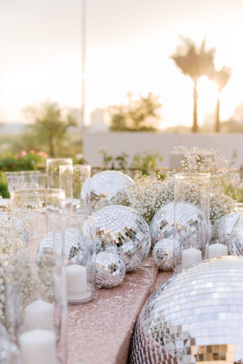 Silver disco balls styled on outdoor table setting for party décor