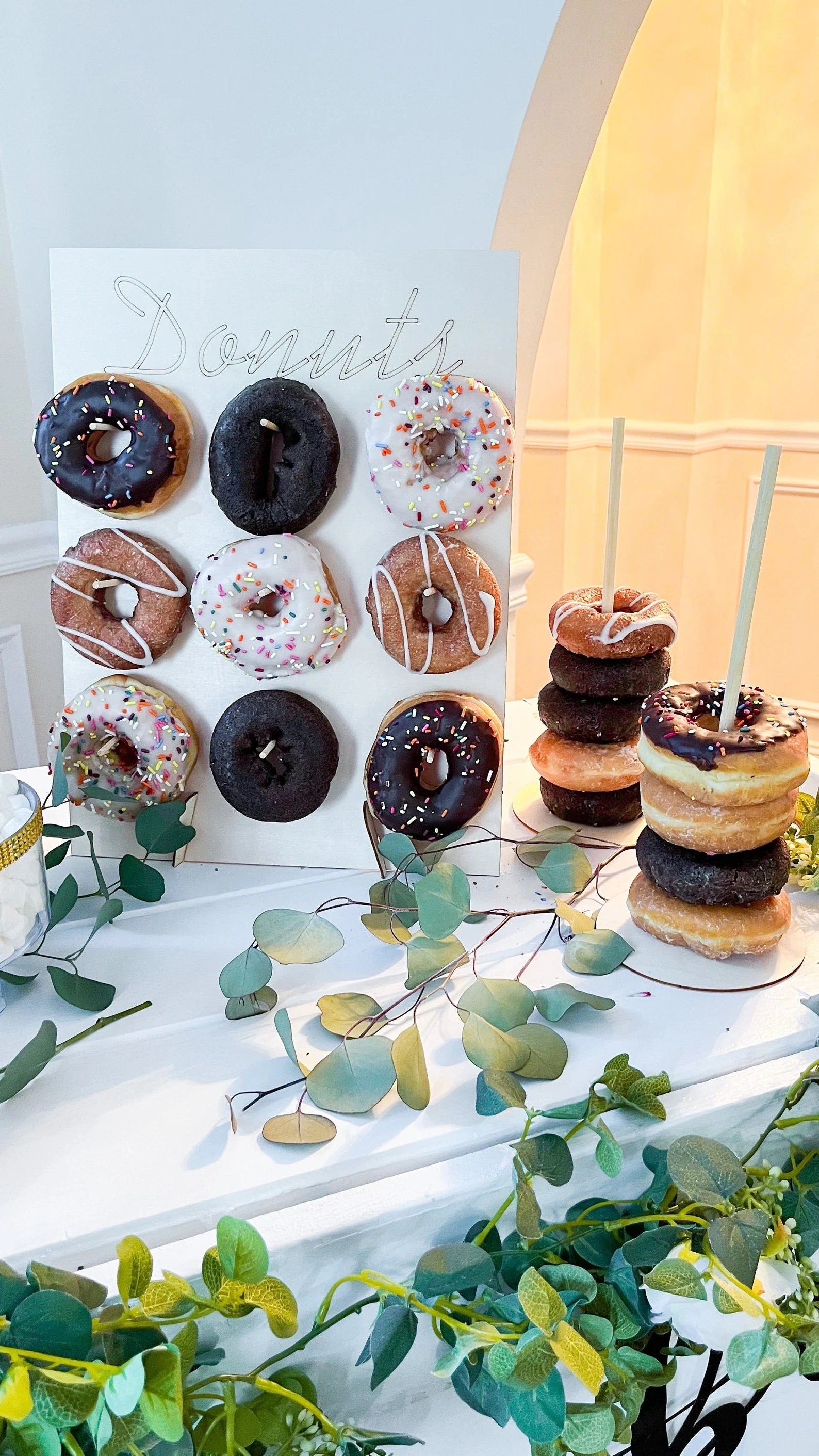 Detail of donuts hanging on white board labeled “Donuts” at the top