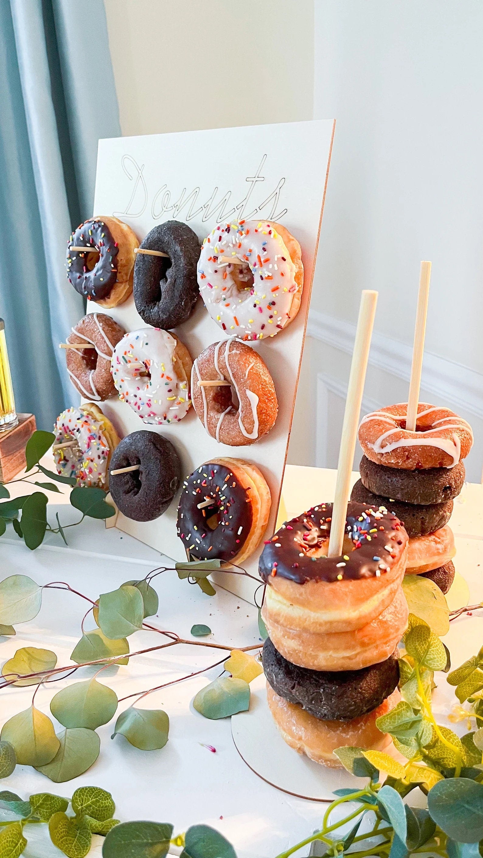 Angle view of donut wall with mixed flavors and sprinkles hanging on pegs