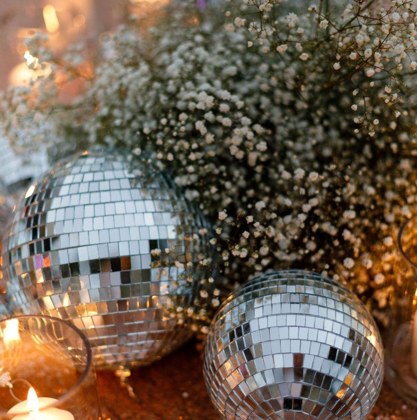 Hanging silver mirror disco balls adding sparkle to a bridal shower setup.