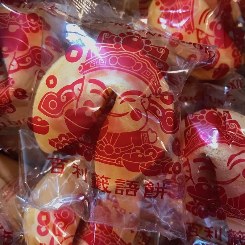 Close-up of individually wrapped fortune cookies for party favors with Chinese take out boxes.
