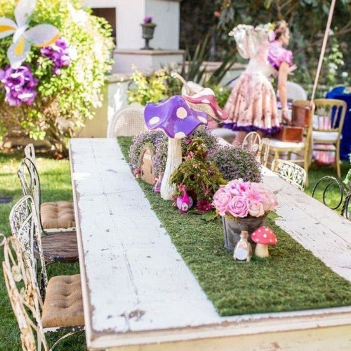 Outdoor garden party table with faux grass runner and pink floral centerpieces
