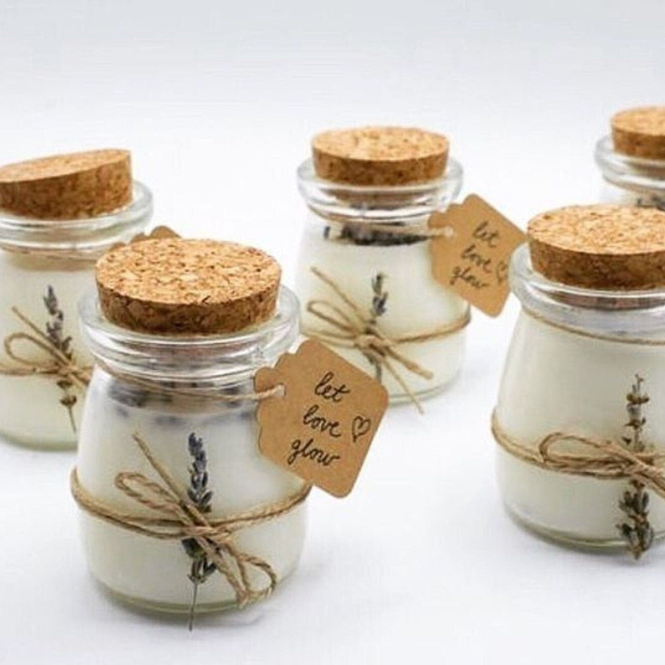 Close-up of favor jars wrapped with twine and kraft labels in rustic style