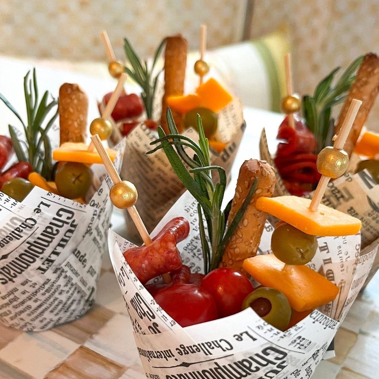 Party appetizers served in charcuterie cups with gold fancy toothpicks
