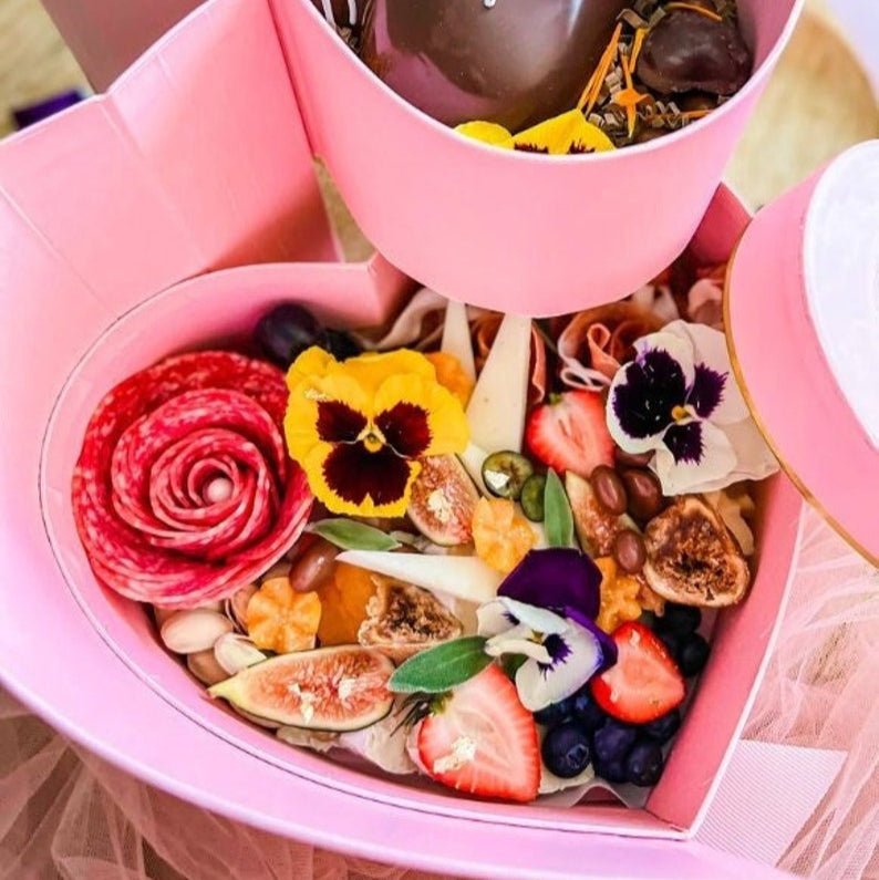 Heart shaped charcuterie gift box with grazing spread of meats, cheese, and fruit