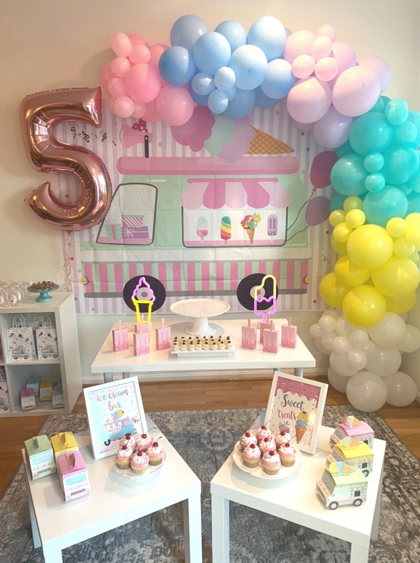 Ice cream truck favor boxes displayed with colorful balloons at a child’s birthday celebration.