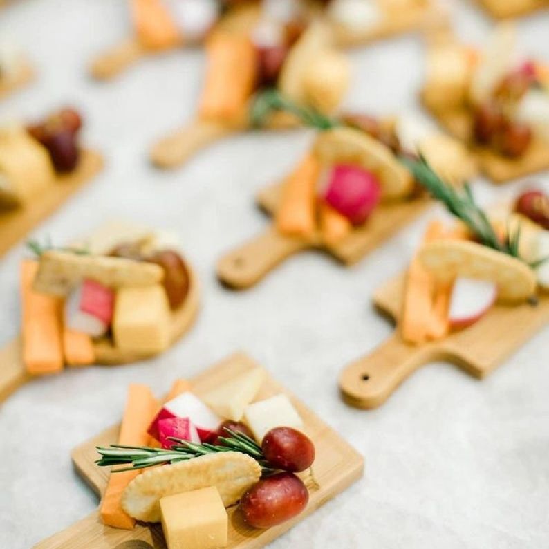 Assortment of bite-size appetizers arranged on multiple mini wooden boards