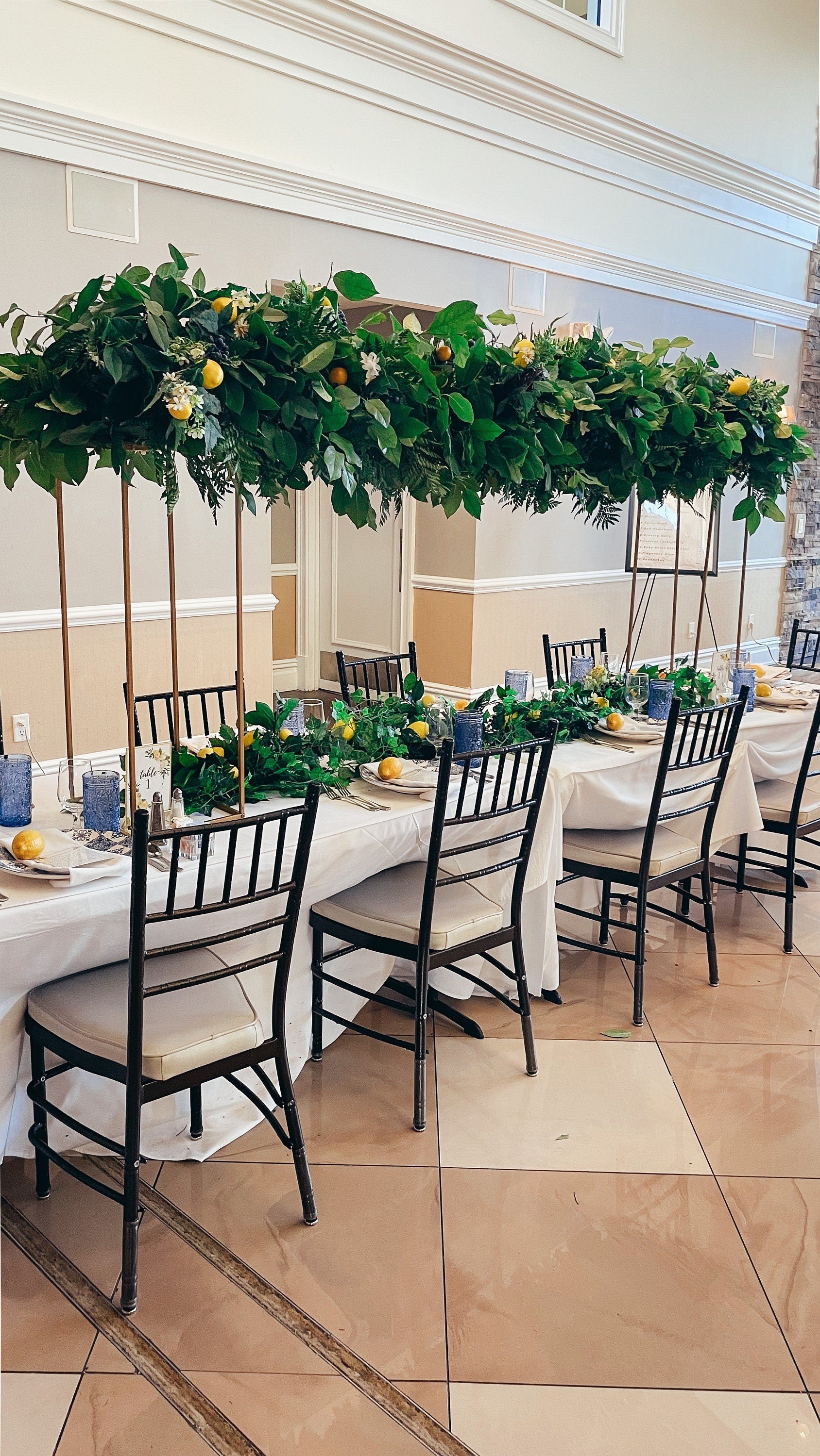 Long dining table decorated with lemon Italian themed baby shower centerpieces and greenery