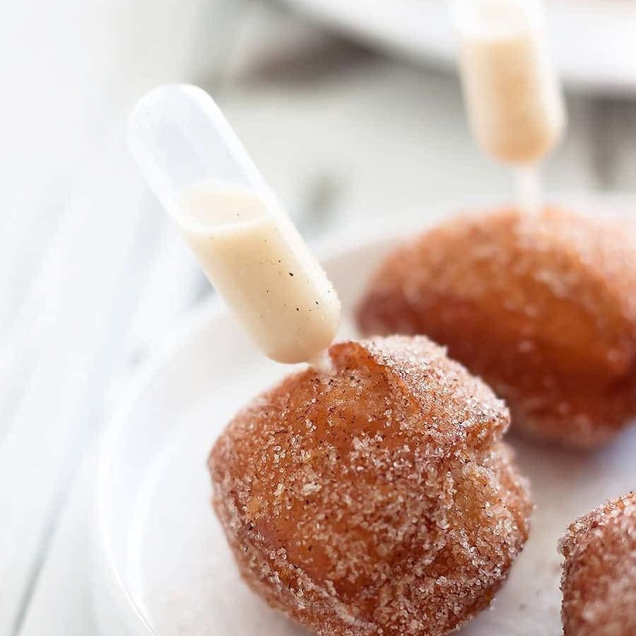 Cinnamon-sugar donut holes with vanilla sauce in mini pipettes