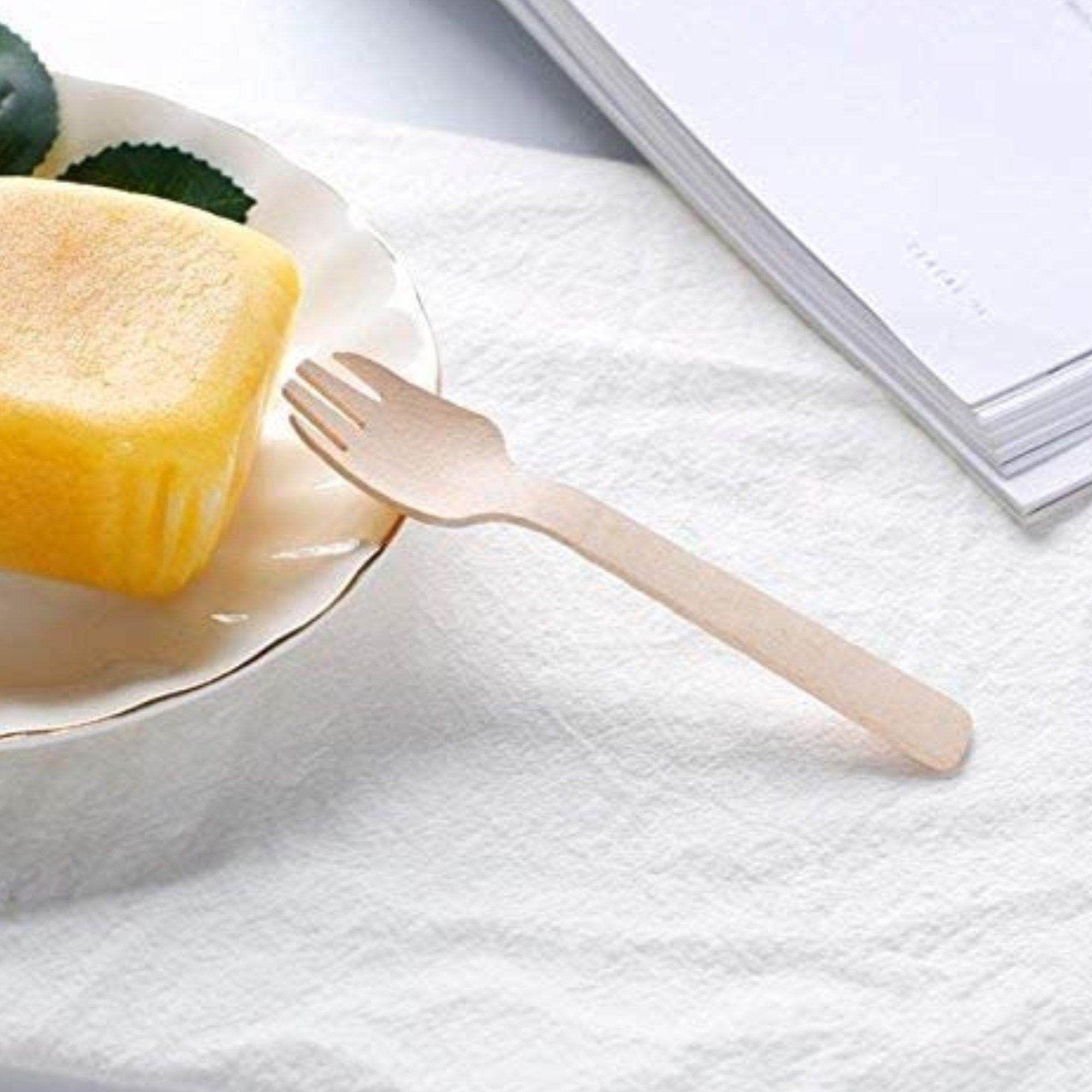 Mini wooden fork on white plate with dessert portion