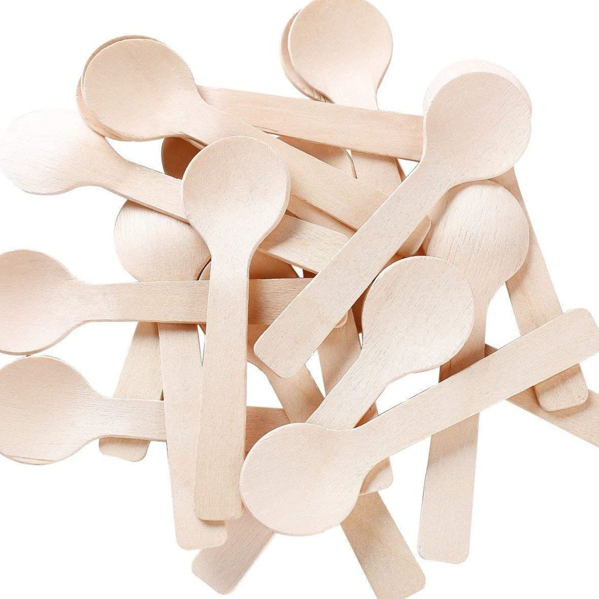 Mini wooden spoon on white plate with dessert portion