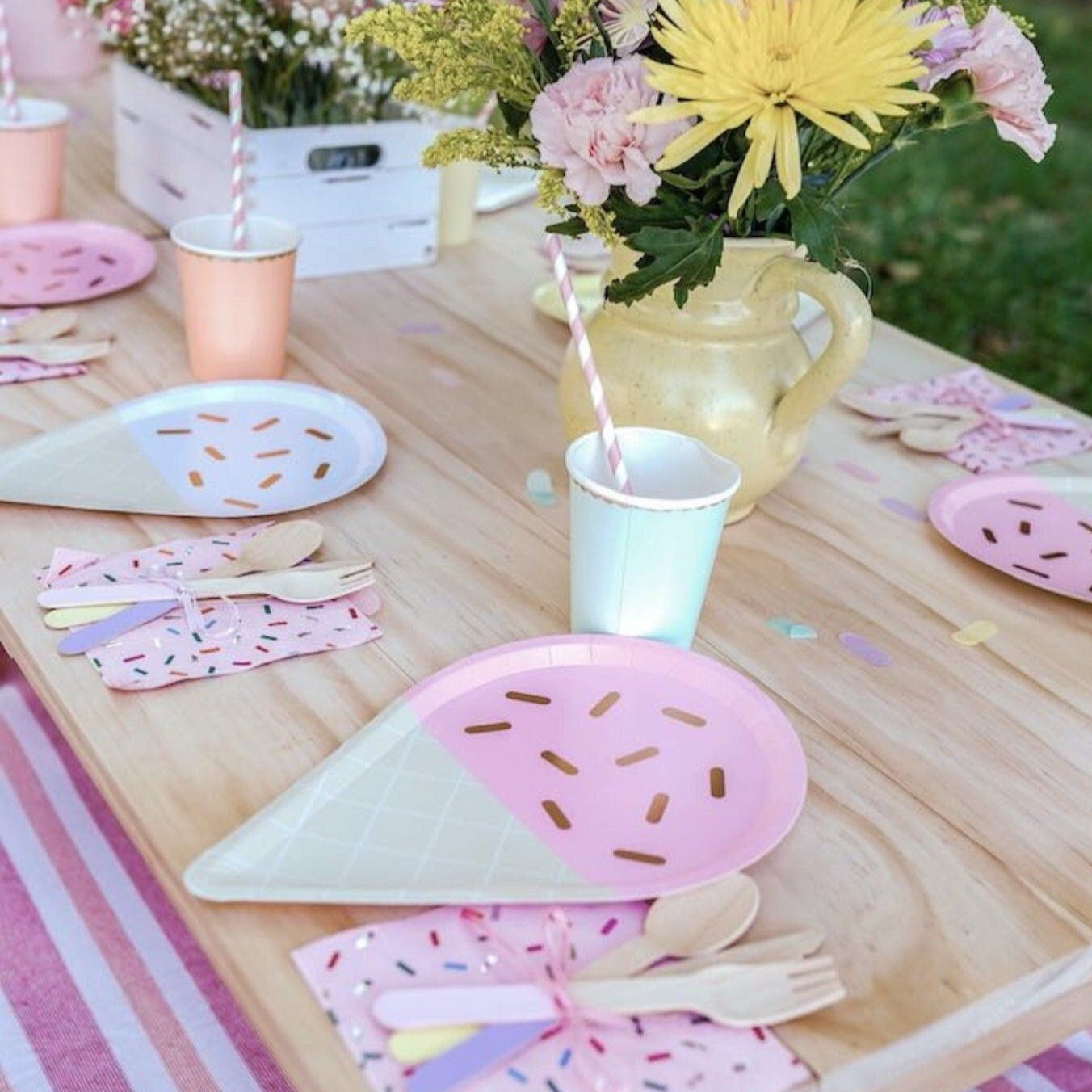 Outdoor ice cream party table with pastel plates, cups, and napkins