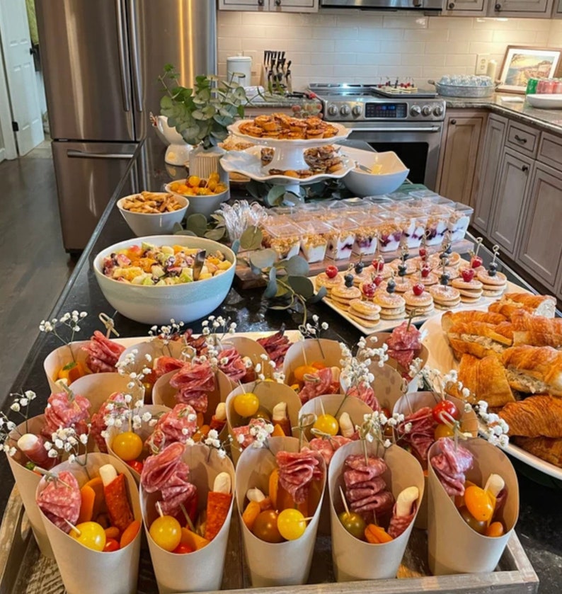Catering setup with beige charcuterie cups filled with snacks and appetizers.