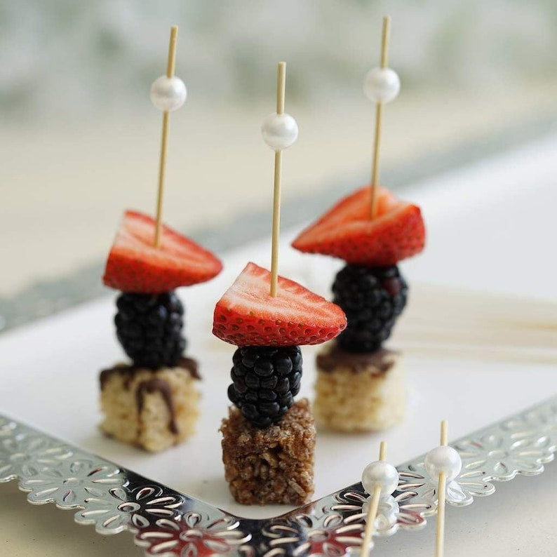 Pearl fancy toothpicks holding strawberries, blackberries, and desserts for charcuterie display