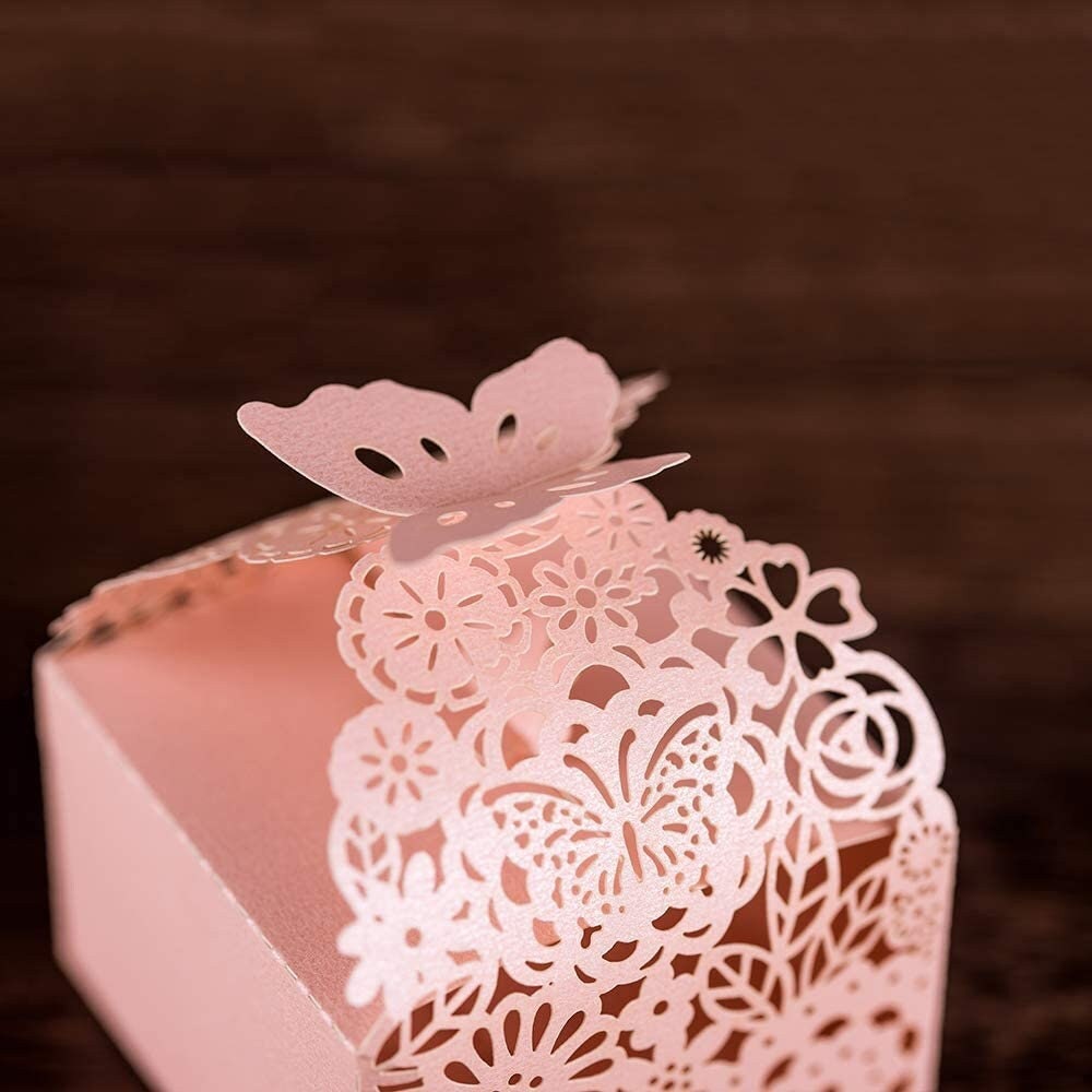Close-up of pink butterfly laser cut favor box with intricate floral design