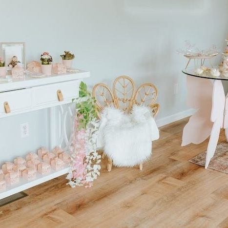 Shelf display of pink butterfly favor boxes decorated with flowers for parties