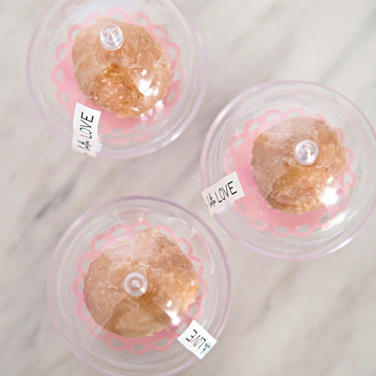 Multiple clear mini cake domes holding desserts on table display