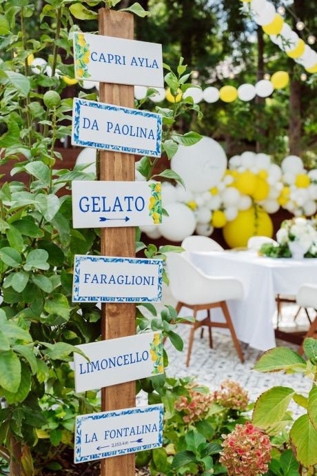 Digital Italian party signs displayed on wooden post with Amalfi lemon and tile designs