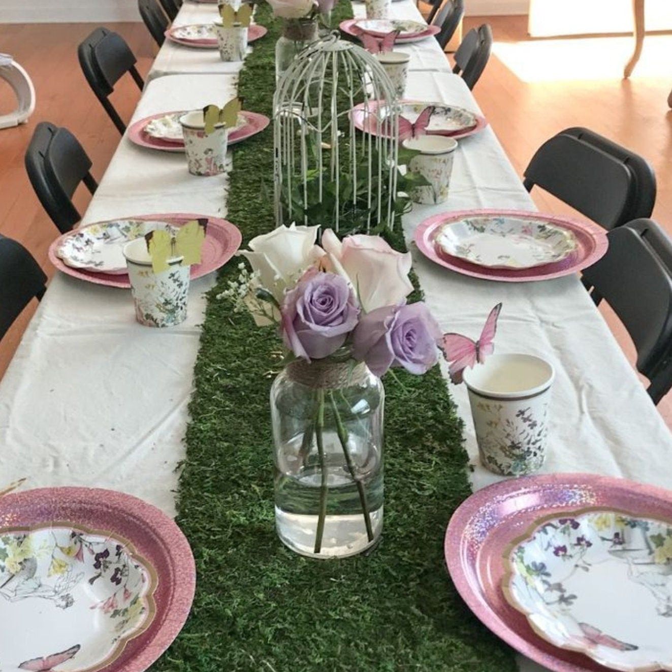 Artificial grass table runner with lavender floral centerpiece and rustic plates