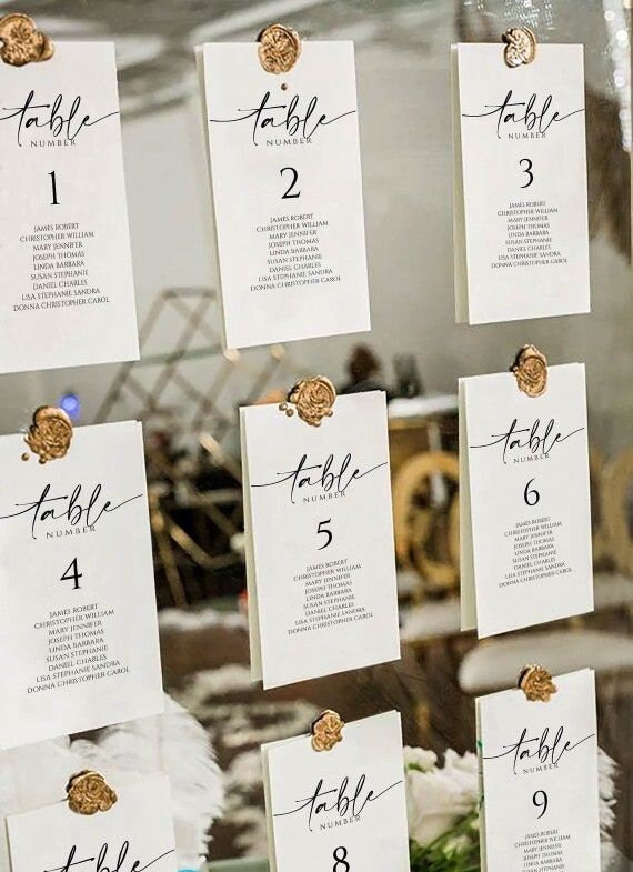 Gold frame seating chart cards attached with mixed-color 1-inch wax seal stickers.
