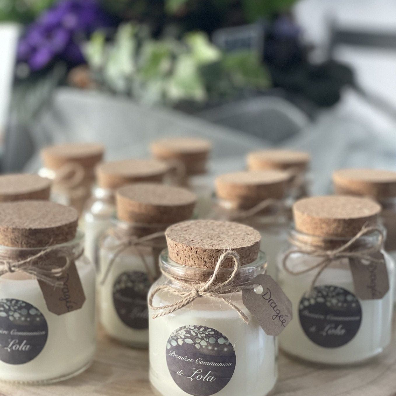 Row of small glass jars with cork lids tied with kraft tags for party favors
