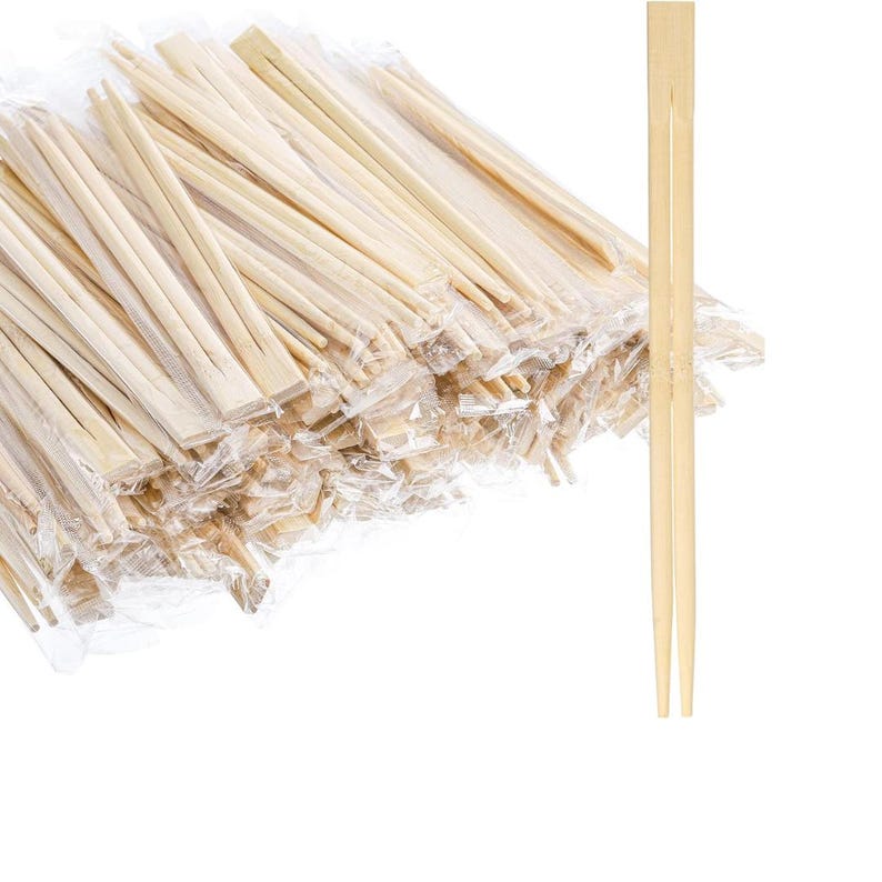 Transparent Chinese food box with dumplings and disposable wooden chopsticks.