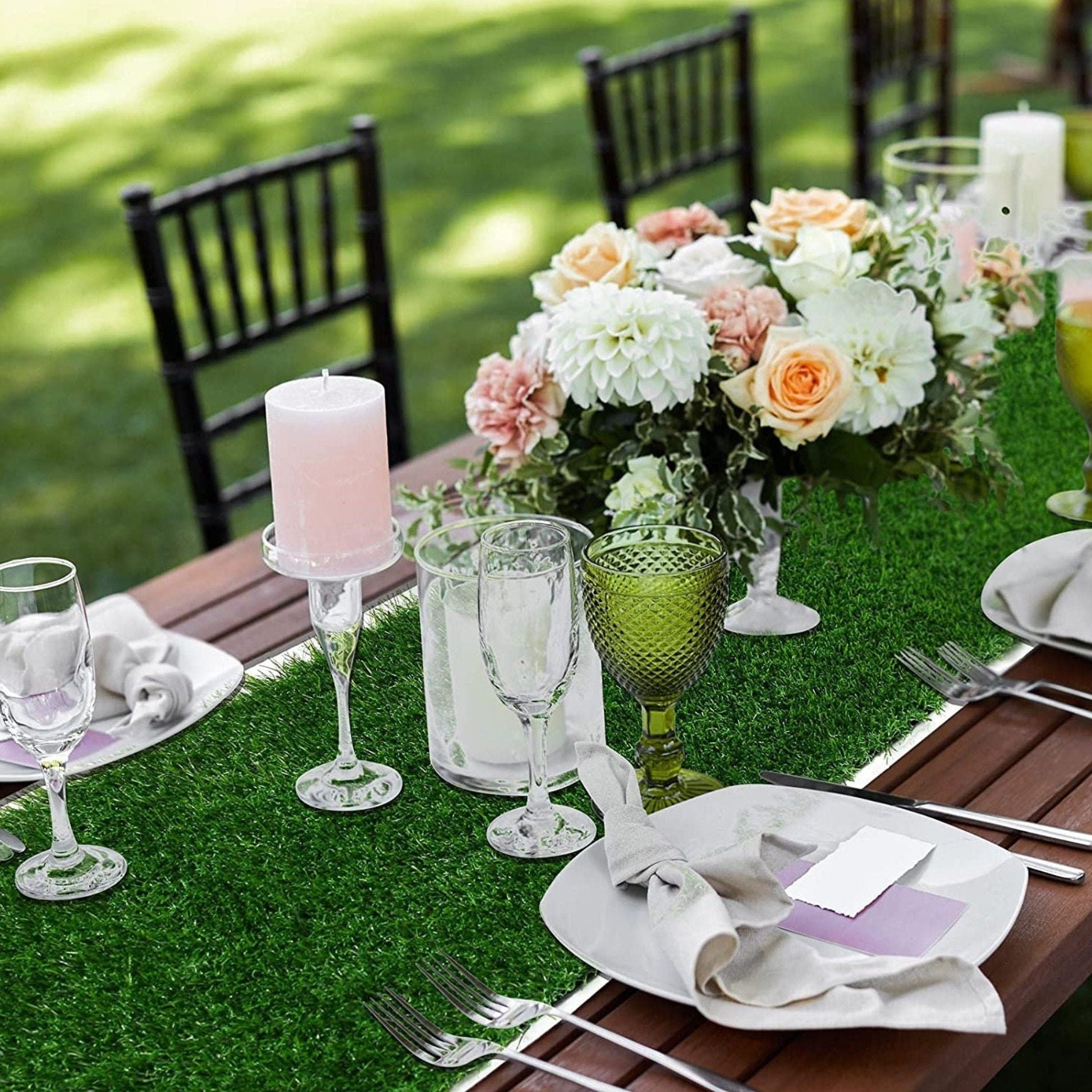 Grass table runner with floral centerpiece and candles for outdoor wedding reception