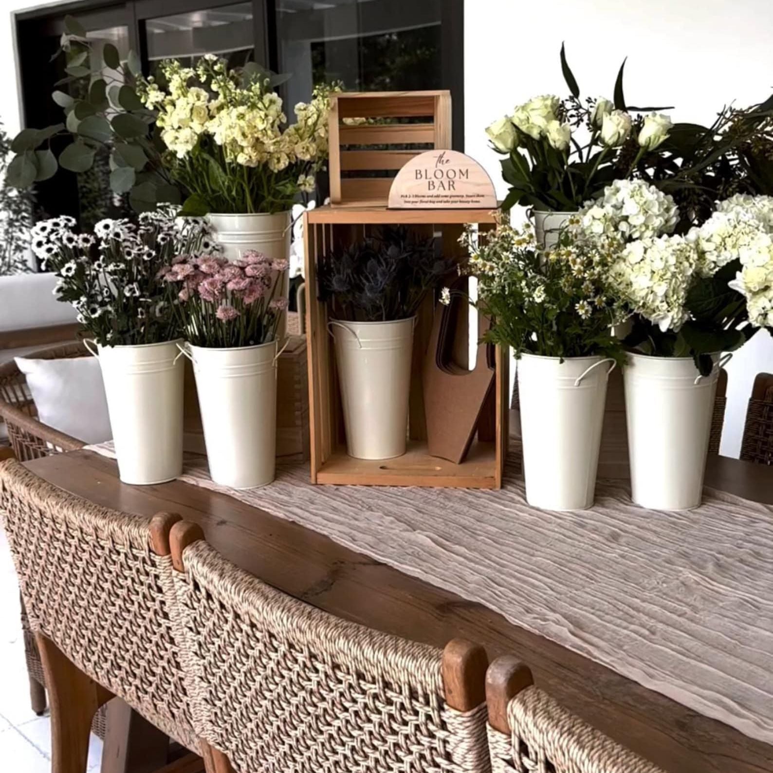 White flower buckets with a classic design, perfect for creating a stunning DIY flower bar arrangement.  