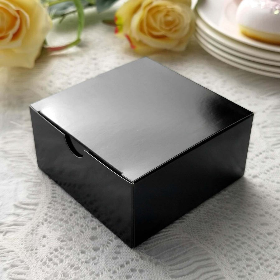 Glossy black party favor box with ribbon & white rose. Modern wedding gift packaging.