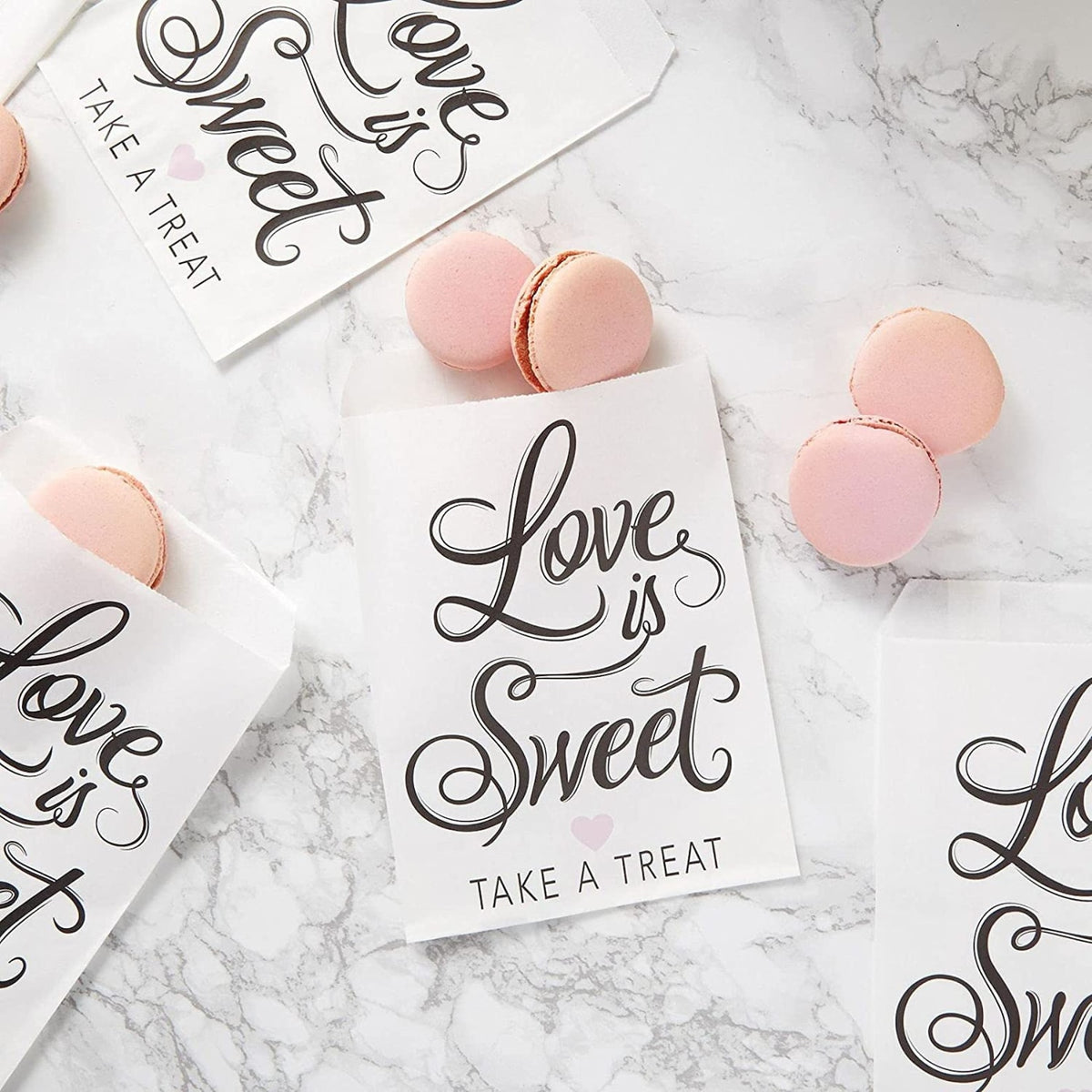 Love is Sweet Take a Treat" paper treat bags. Small white favor bags for a wedding or party candy bar.