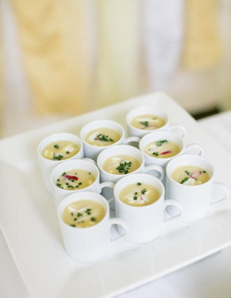 White appetizer soup mugs displayed with mini spoons