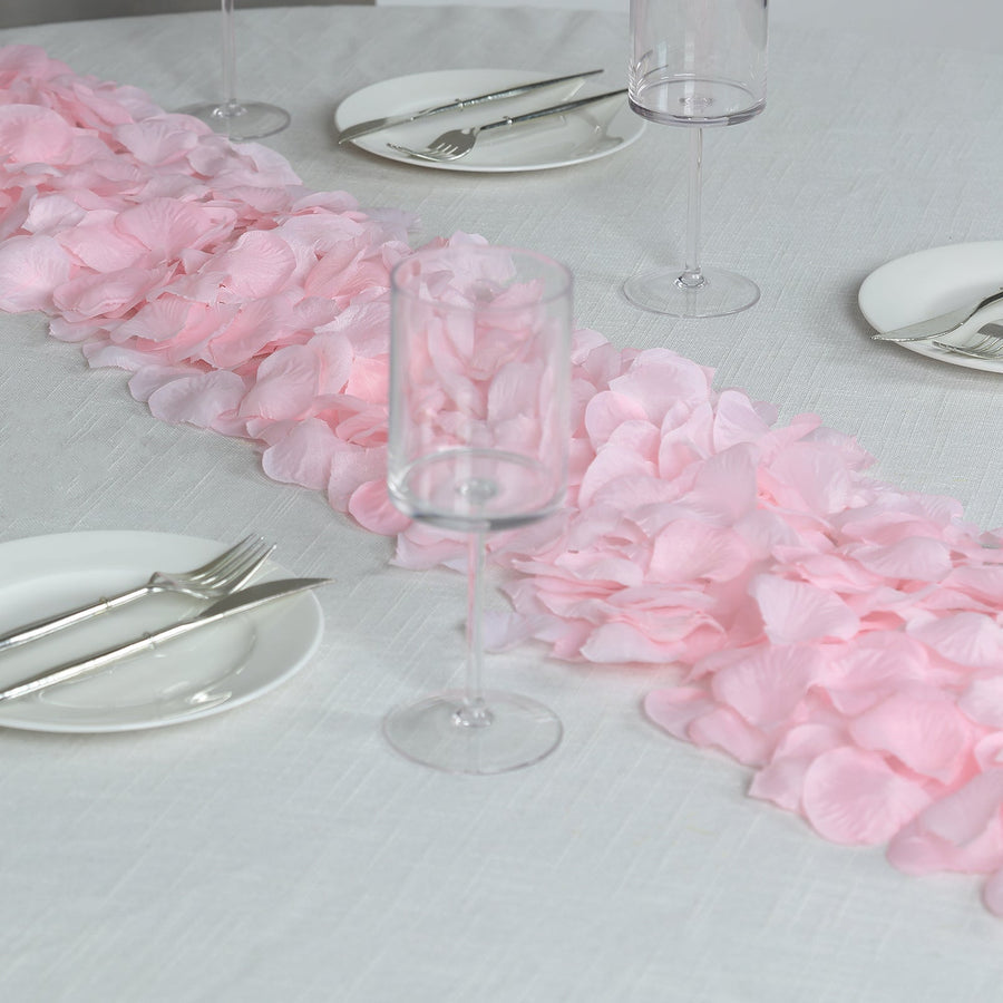 Decorative silk rose petals arranged on table runner for celebrations