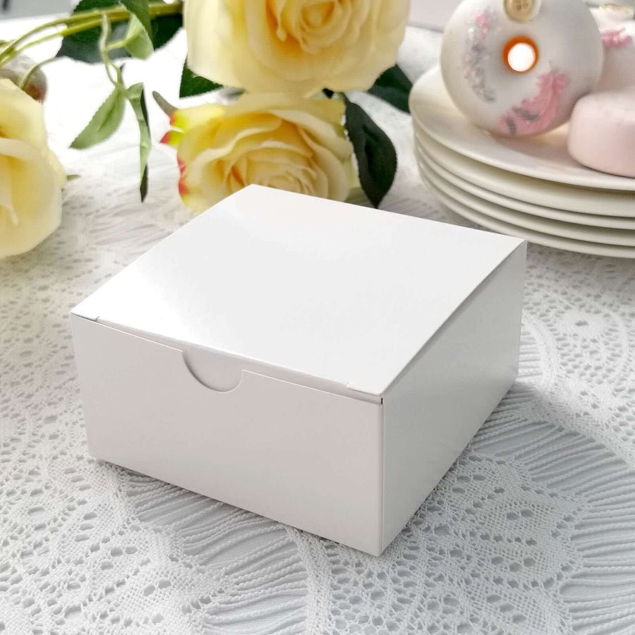 Light pink favor box tied with a white ribbon and rose. Elegant gift packaging for wedding favors.