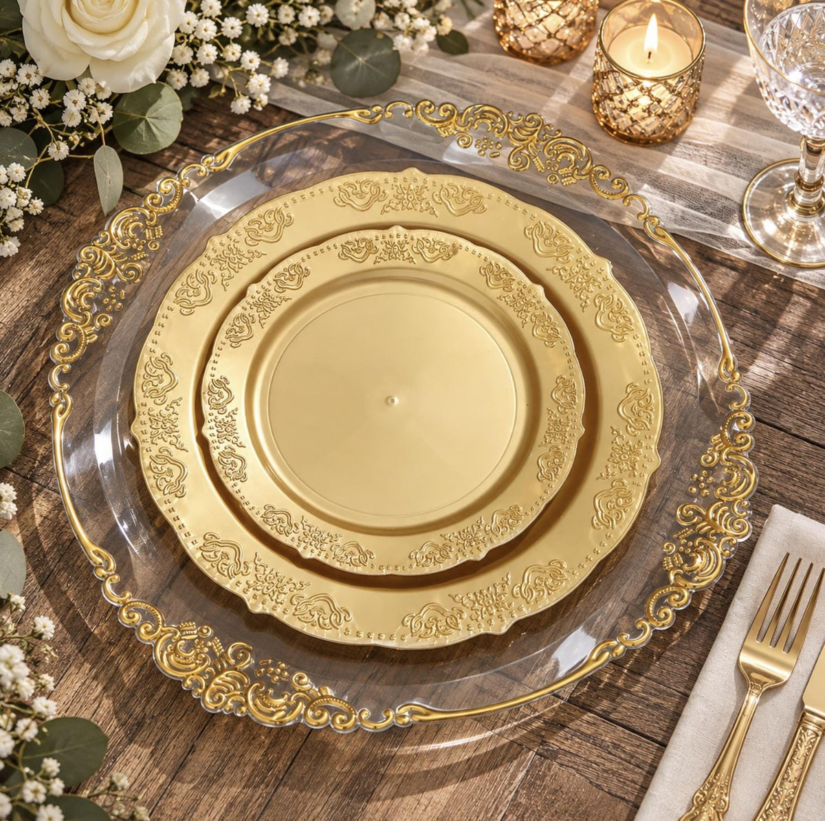 White plastic dinner plate with gold baroque rim, set with elegant gold cutlery. Disposable party tableware.