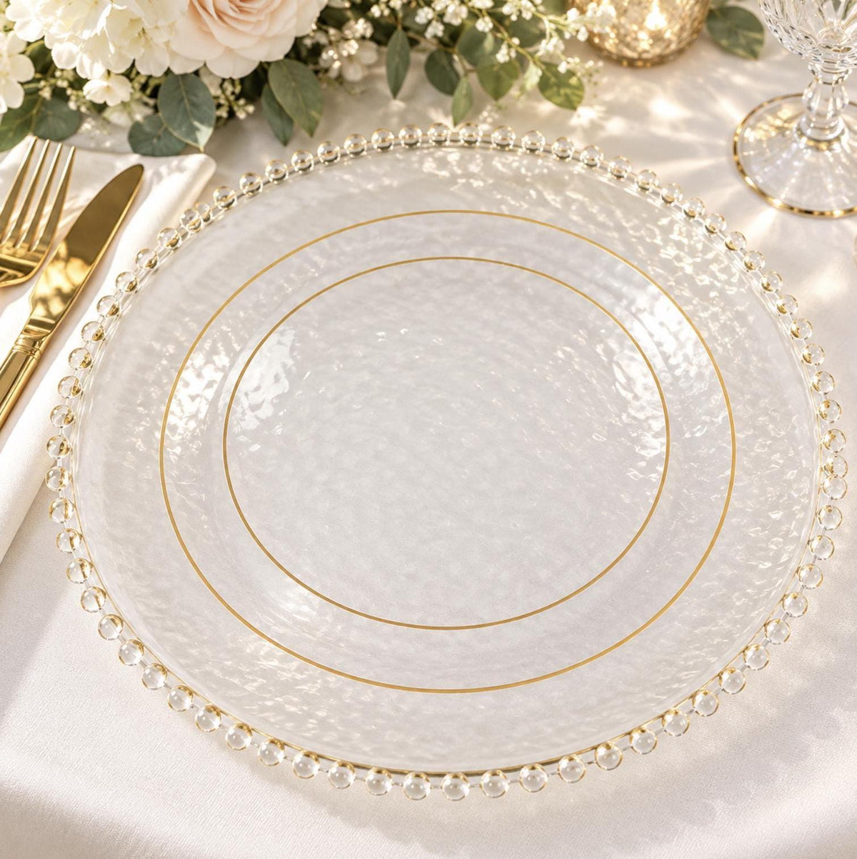 White plastic dinner plate with a gold rim. Disposable premium tableware for wedding receptions.
