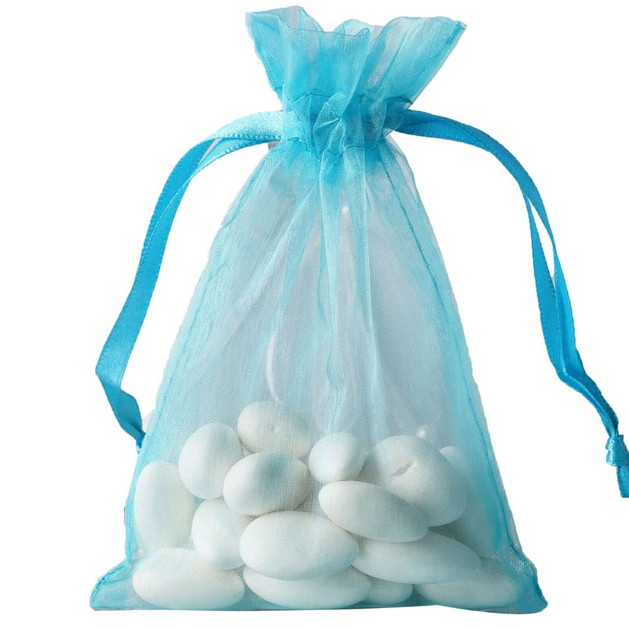 Turquoise organza drawstring gift bag filled with colorful candy eggs – elegant 4"x6" favor pouch for weddings and special events