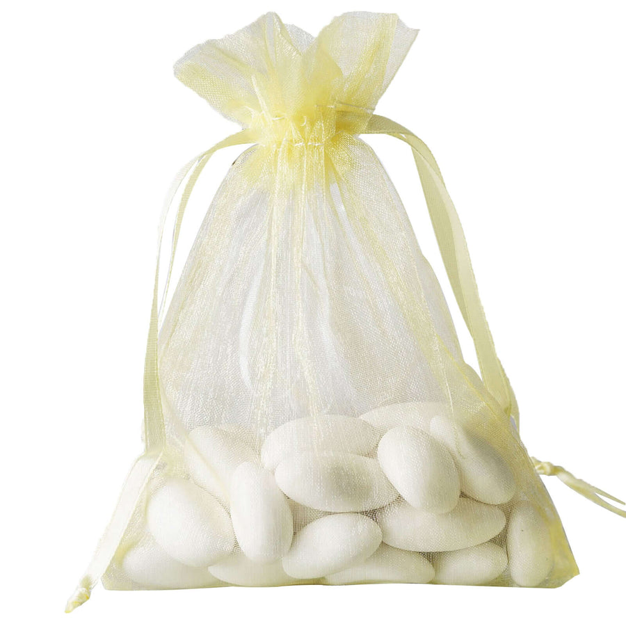 Yellow organza bag filled with sugared almonds, perfect for wedding favors.